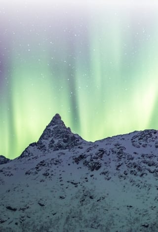 Northern lights showing over snowy mountains