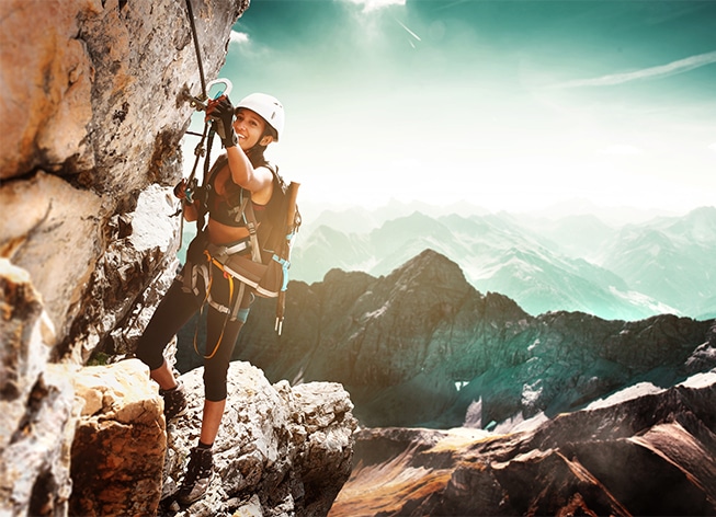 Woman rock climbing on a mountain range
